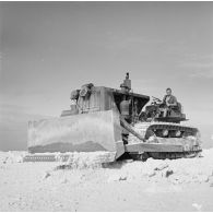 Engin tractopelle chenillé du génie sur un chantier de construction de piste. Peut-être sur l'atoll de Moruroa.