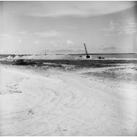 Chantier de construction et engin de levage. Peut-être sur l'atoll de Moruroa.