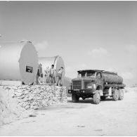 Camion-citerne et citernes d'essence. Personnels militaires. Peut-être sur l'atoll de Moruroa.