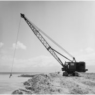 Engin de levage chenillé du génie en action au bord de l'eau. Peut-être sur l'atoll de Moruroa. (CAPL Marion, Anita)