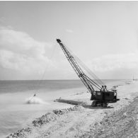 Engin de levage chenillé du génie en action au bord de l'eau. Peut-être sur l'atoll de Moruroa. (CAPL Marion, Anita)