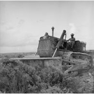 Engin tractopelle chenillé du génie sur un chantier de construction. Terrassement. Peut-être sur l'atoll de Moruroa.