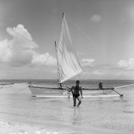 Alain Peyrefitte, ministre de l'Information, sort de l'eau, en arrière-*plan, une pirogue à balancier.