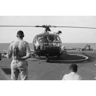 Départ du général De Gaulle du croiseur De Grasse après le déclenchement de l'essai nucléaire Bételgeuse, et du vice-amiral Jean Lorain, commandant du groupe opérationnel des expérimentations nucléaires (GOEN), par hélicoptère Alouette III.