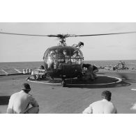 Départ du général De Gaulle du croiseur De Grasse après le déclenchement de l'essai nucléaire Bételgeuse, et du vice-amiral Jean Lorain, commandant du groupe opérationnel des expérimentations nucléaires (GOEN), par hélicoptère Alouette III.