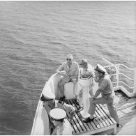 L'amiral Georges Cabanier (de dos), chef d'état-major de la Marine (CEMM), avec Pierre Messmer, ministre des Armées, sur un bâtiment en mer en visite à Moruroa, 29 mars 1965.