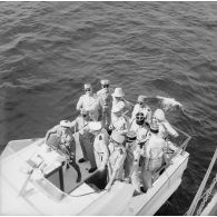 Pierre Messmer, ministre des Armées, l'amiral Cabanier, chef d'état-major de la marine (CEMM), et les officiers généraux à bord d'un canot lors d'une visite sur l'atoll de Moruroa.