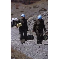 Deux sapeurs du 6e régiment de génie (6e RG) portent des mines antichar neutralisées.