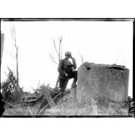 The Battle of Flanders, a British Royal Engineer establishing communication at on old german machine gun position. [légende d'origine]