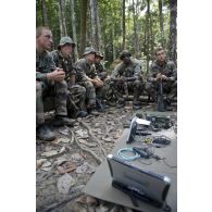 Des stagiaires découvrent différents matériels de transmission en forêt en zone d'instruction de Tuff, en Guyane française.