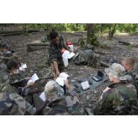 Un instructeur du 9e régiment d'infanterie de marine (9e RIMa) présente différents matériels de transmission en forêt à des stagiaires en zone d'instruction de Tuff, en Guyane française.