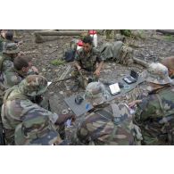 Un instructeur du 9e régiment d'infanterie de marine (9e RIMa) présente différents matériels de transmission en forêt à des stagiaires en zone d'instruction de Tuff, en Guyane française.