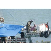 Un membre de l'équipe de visite de La Gracieuse inspecte la dunette arrière d'une tapouille brésilienne prise en flagrant délit de pêche illégale en Guyane française.