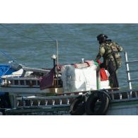 Un membre de l'équipe de visite de La Gracieuse inspecte la dunette arrière d'une tapouille brésilienne prise en flagrant délit de pêche illégale en Guyane française.