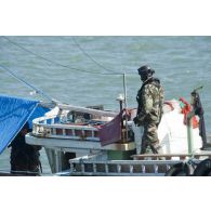 Un membre de l'équipe de visite de La Gracieuse inspecte la dunette arrière d'une tapouille brésilienne prise en flagrant délit de pêche illégale en Guyane française.