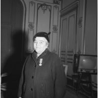 Femme rapatriée d'Algérie posant avec sa médaille d'honneur départementale et communale.