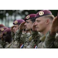 Des parachutistes néerlandais saluent lors de la sonnerie des hymnes nationaux pour une cérémonie à Cincu, en Roumanie.