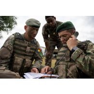 Un artilleur du 68e régiment d'artillerie d'Afrique (RAA) observe ses homologues roumains du 206e bataillon d'artillerie guider leur tir au mortier par radio sur le champ de tir de Cincu, en Roumanie.