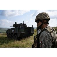 Un soldat roumain du 20e bataillon d'infanterie communique avec un véhicule blindé Piranha V sur le champ de tir de Cincu, en Roumanie.