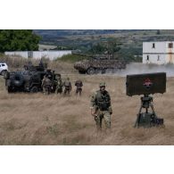 Des soldats français visitent un blindé portugais URO VAMTAC  à Cincu, en Roumanie.