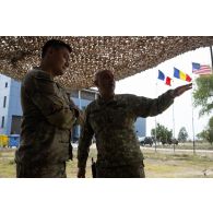 Un officier américain de la 1st multi-domain Task Force discute avec son homologue roumain du 33e bataillon d'infanterie de montagne au centre opérationnel (CO) de la base de Cap Midia, en Roumanie.