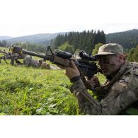 Un soldat américain du 32e régiment d'infanterie sécurise le secteur au moyen de son fusil d'assaut M4-A1 à Brădet, en Roumanie.