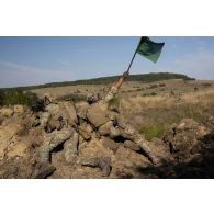 Un soldat belge du régiment Libération-5e de ligne brandit un drapeau pour informer les troupes en retrait de l'évolution de l'assaut dans une tranchée à Cincu, en Roumanie.