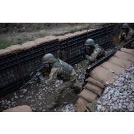 Des soldats portugais du 14e régiment d'infanterie progressent dans les boyaux d'une tranchée à Cincu, en Roumanie.