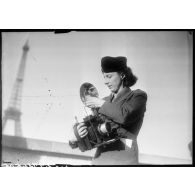 Une photographe des forces féminines de l'Air équipée d'un appareil Speed Graphic.