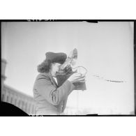 Une photographe des forces féminines de l'Air équipée d'un appareil Speed Graphic.