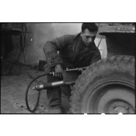 Maintenance sur la jeep Brouillard de la 2e division blindée (2e DB) par un mécanicien d'une unité du matériel.