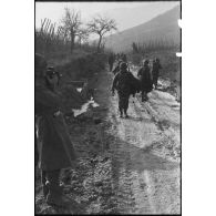 Patrouille de fantassins de la 3e division d'infanterie américaine (DIUS) sur un chemin boueux.