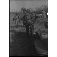 Patrouille de fantassins de la 3e division d'infanterie américaine (DIUS) sur un chemin boueux.