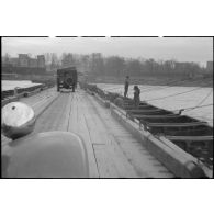 Le véhicule du service cinématographique de l'Armée (SCA) emprunte le pont flottant Mannheim-Ludwigshafen monté par le génie américain le 30 mars 1945.