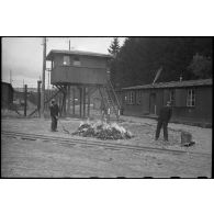 Des pompiers allemands brûlent les vêtements souillés des déportés qui passent à l'épouillage et à qui on fournit des vêtements propres dans le camp de Vaihingen récemment libéré.