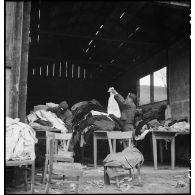 Des soldats français trient des vêtements confisqués à la population civile allemande au profit des déportés libérés du camp de Vaihingen.