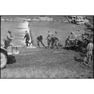 Des soldats prisonniers et des civils allemands réquisitionnés aident au franchissement d'un cours d'eau par des véhicules du 2e bataillon de zouaves portés (2e BZ).