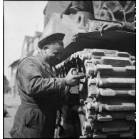 Intervention sur les galets d'une chenille d'un char Sherman M4 par des soldats du 11e GERD (11e groupe d'escadrons de réparation divisonnaire).