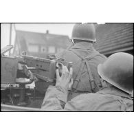 Membres d'équipage d'un scout-car ou d'un half-track. Au premier plan, le servant d'une mitrailleuse 12,7 mm.