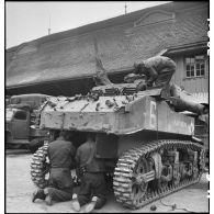 Maintenance sur un canon automoteur de 75 mm Howitzer Motor Carriage M8 baptisé Montbrun par des hommes du 3e escadron du 11e groupe d'escadrons de réparation divisionnaire (11e GERD).