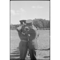 Le général de corps d'armée Philippe Leclerc décore un officier lors de la la cérémonie d'adieu à sa division, la 2e division blindée (2e DB).