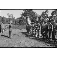 Le général de corps d'armée Leclerc salue l'étendard du 501e régiment de chasseurs de chars (501e RCC) avant de le décorer lors de la cérémonie d'adieu à la 2e division blindée (2e DB).