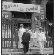 Des autorités civile et militaires sortent d'une exposition intitulée Marine au combat au palais de la Bourse.