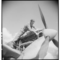 Un mécanicien assure la maintenance du moteur d'un Spitfire Mk V du groupe de chasse (GC) II/7 Nice.