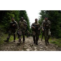 Des soldats du 35e régiment d'infanterie (RI) échangent avec leur homologue roumain lors d'une randonnée en montagne à Lunca de Sus, en Roumanie.