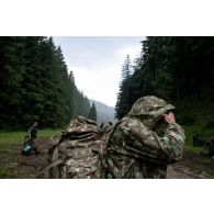 Un soldat roumain s'abrite de la pluie lors d'une randonnée en montagne à Lunca de Sus, en Roumanie.