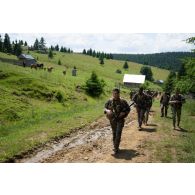 Des soldats du 35e régiment d'infanterie (RI) marchent au côtés de leurs homologues roumains pour une randonnée en montagne à Lunca de Sus, en Roumanie.