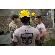 Des instructeurs roumains dirigent un briefing auprès des soldats du 35e régiment d'infanterie (RI) pour une descente en rappel à Lunca de Sus, en Roumanie.