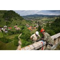 Un soldat du 35e régiment d'infanterie (RI) s'apprête à descendre un viaduc en rappel encadré par un instructeur roumain à Lunca de Sus, en Roumanie.