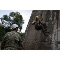 Un soldat du 35e régiment d'infanterie (RI) descend un viaduc en rappel sous la supervision d'un instructeur roumain à Lunca de Sus, en Roumanie.